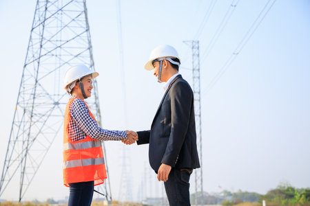 Asian engineers shake hands after successful construction projectの写真素材