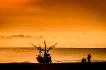 Fisher boat and family on Hua Hin beach  sunrise background Thailandの写真素材