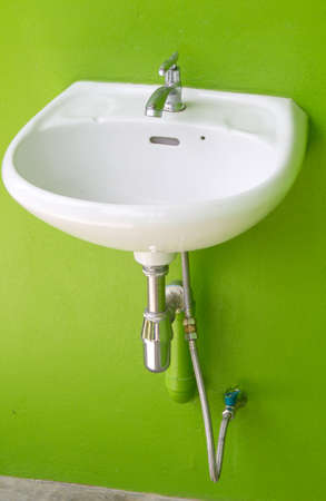 Bathroom interior with white sink and faucet on green wallの写真素材