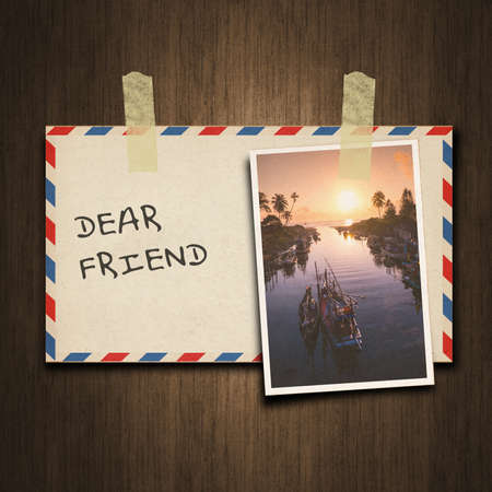 Old vintage style envelope and postcard on wood background