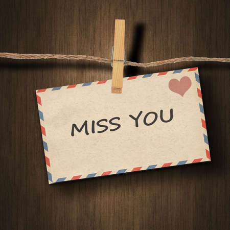 text miss you on the old envelope and clothes peg wood backgroundの写真素材