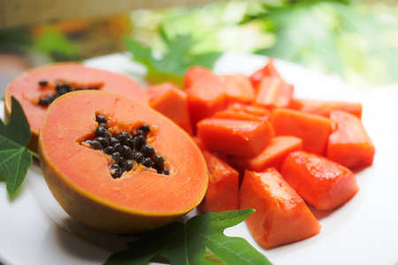 sweet papaya on the dish with green papaya leafの写真素材