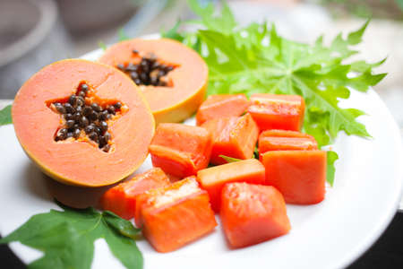 sweet papaya on the dish with green papaya leafの写真素材