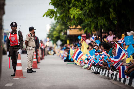 HUA HIN - AUGUST 1 : Well-whisher wait at Klai Kangwon Palace to get a glimpse of the King and Queen when their motorcade left to travel to Klai Kangwon Palace in Hua Hin district of Prachuap Khiri Khan. on AUG 1,2013 in HUA HIN ,THAILAND.のeditorial素材
