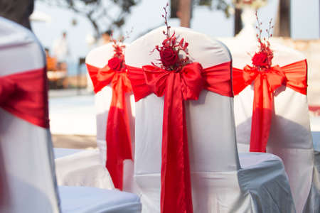 wedding chairs decorated with red rosesの写真素材
