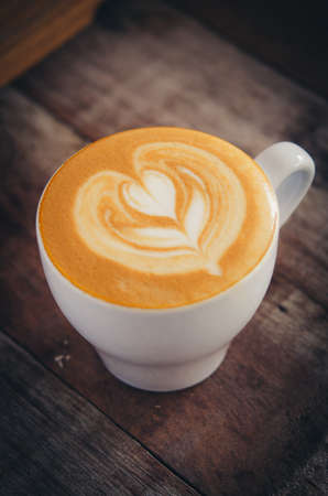 Marco shot coffee latte art on the wood desk vintage style color toneの写真素材