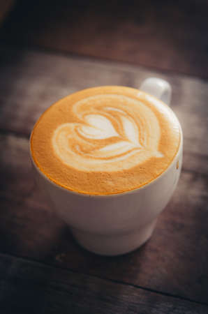 Marco shot coffee latte art on the wood desk vintage style color toneの写真素材