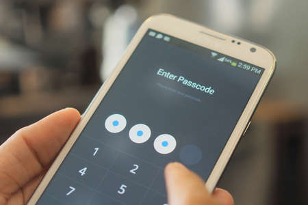 hand and smartphone with password code in screenの写真素材