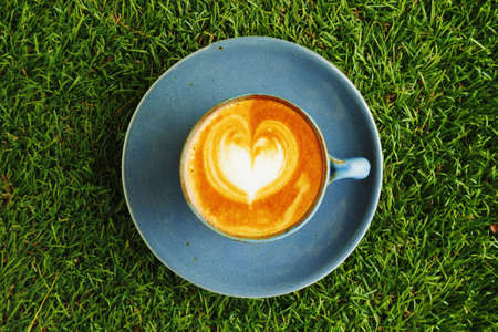 cup of coffee on the green grassの写真素材