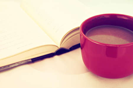 open book with cup of coffee in vintage light tone colorの写真素材