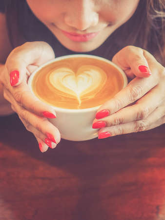 Beautiful Girl Drinking Tea or Coffee in vintage color toned styleの写真素材