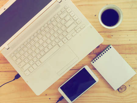 Cup of coffee and laptop on wooden table