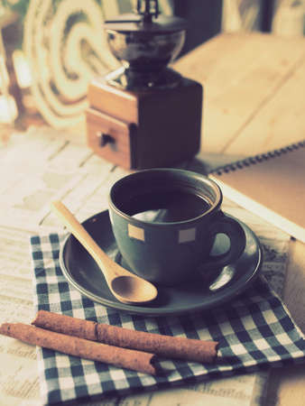 cup of coffee on the wood desk with business newspaper in vintage color tonedの写真素材