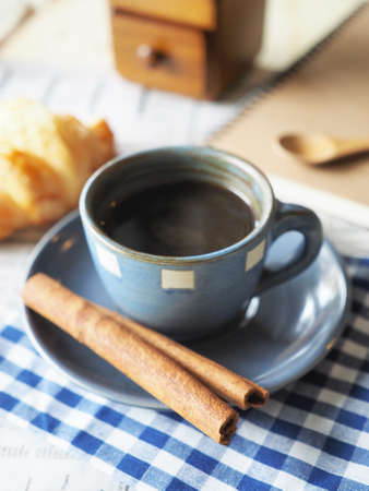 cup of coffee on the wood desk with business newspaper in vintage color tonedの写真素材