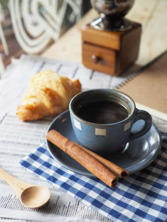 cup of coffee on the wood desk with business newspaper in vintage color tonedの写真素材