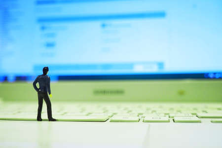 miniature businessman standing on the laptop : concept idea about making money with internet e-commerceの写真素材