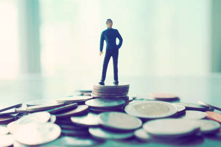 miniature businessman sitting on the coin : concept idea about making money with internet e-commerceの写真素材