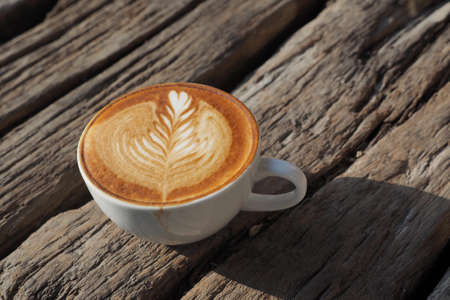 cup of coffee latte art on the wood background in vintage color styleの写真素材