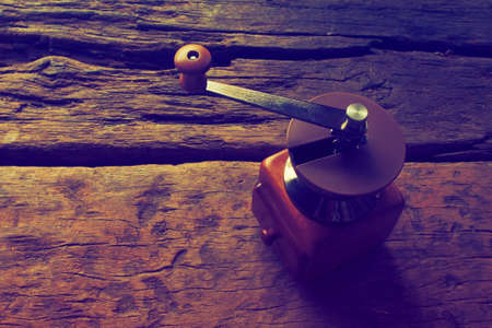 Nostalgic coffee grinder on old table and textured wood backgroundの写真素材