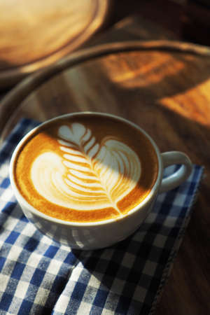 vintage color tone of  cup of coffee with red heart on the table coffee shopの写真素材