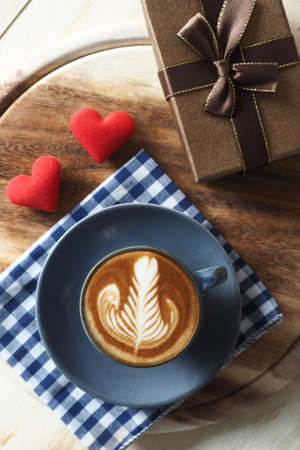 vintage color tone of  cup of coffee with red heart on the table coffee shopの写真素材