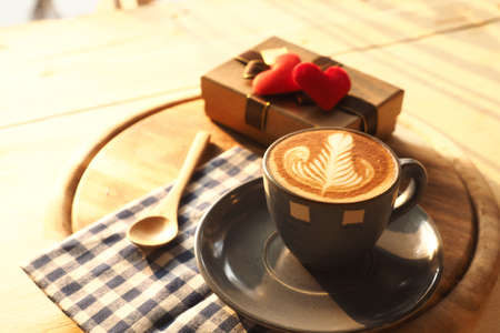 vintage color tone of  cup of coffee with red heart on the table coffee shopの写真素材