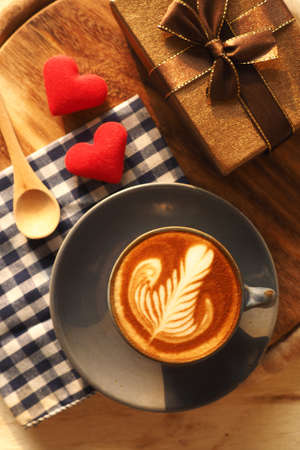 vintage color tone of  cup of coffee with red heart on the table coffee shopの写真素材