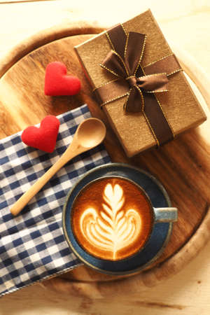 vintage color tone of  cup of coffee with red heart on the table coffee shopの写真素材