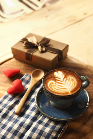 vintage color tone of  cup of coffee with red heart on the table coffee shopの写真素材