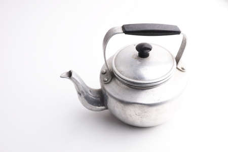 Old aluminum kettle with wooden handle isolated on white backgroundの写真素材