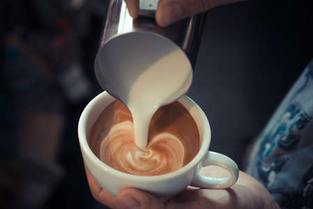 cup of coffee latte art on the wood background in vintage color styleの写真素材