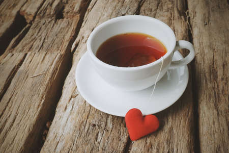 hot tea and red heart on the wood texture vintage colorの写真素材