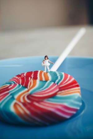 miniature people : little girl walking on the colorful lollipopの写真素材