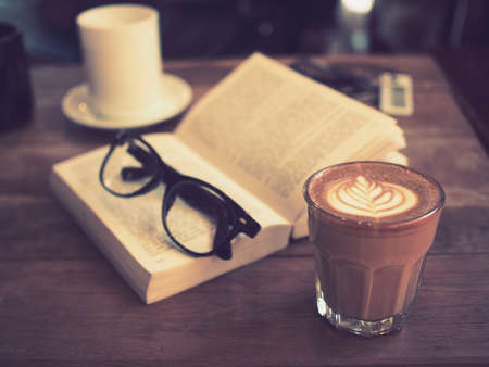 cup of coffee latte art on the wood desk in vintage color toneの写真素材