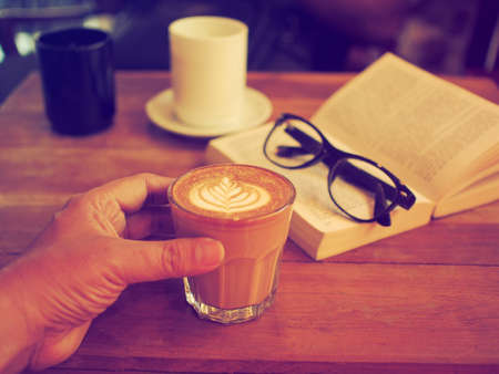 cup of coffee latte art on the wood desk in vintage color toneの写真素材