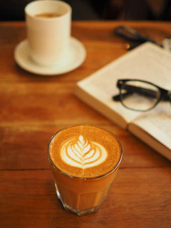 cup of coffee latte art on the wood desk in vintage color toneの写真素材