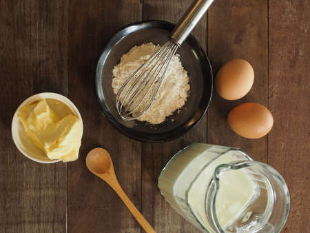 Baking cake ingredients. Bowl, flour, eggs on the wood deskの写真素材