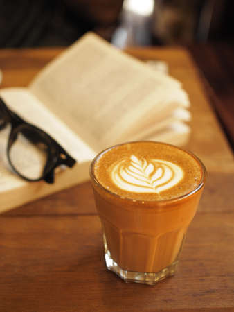 cup of coffee latte art on the wood desk in vintage color toneの写真素材