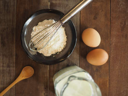 Baking cake ingredients. Bowl, flour, eggs on the wood deskの写真素材