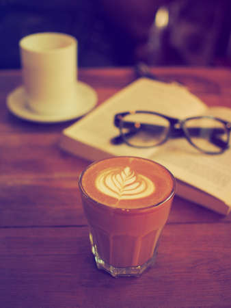 cup of coffee latte art on the wood desk in vintage color toneの写真素材
