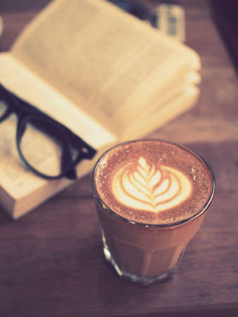 cup of coffee latte art on the wood desk in vintage color toneの写真素材