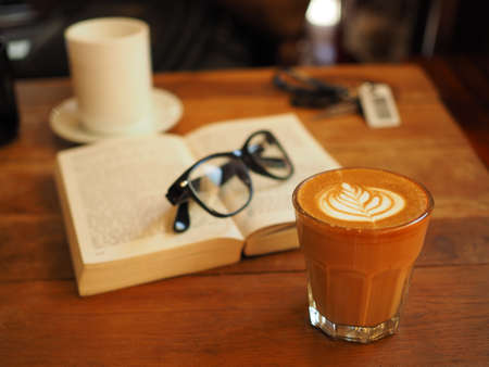 cup of coffee latte art on the wood desk in vintage color toneの写真素材