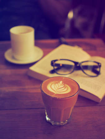 cup of coffee latte art on the wood desk in vintage color toneの写真素材
