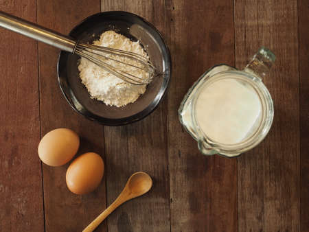 Baking cake ingredients. Bowl, flour, eggs on the wood deskの写真素材