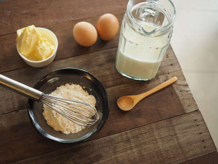 Baking cake ingredients. Bowl, flour, eggs on the wood deskの写真素材
