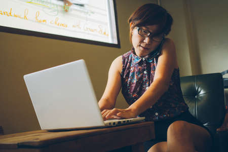Asia woman with notebook in coffee shopの写真素材