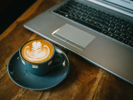 cup of coffee latte on the wood texture   in vintage color toneの写真素材
