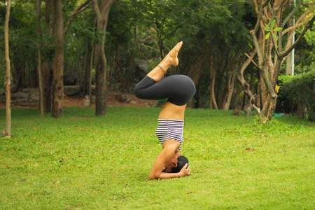 Young woman doing yoga exercises in the garden parkの写真素材
