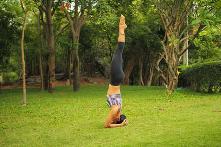Young woman doing yoga exercises in the garden parkの写真素材