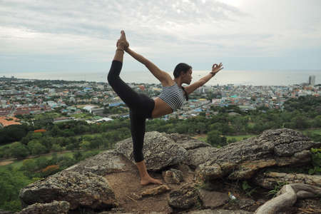 Young woman doing yoga exercises in the garden parkの写真素材